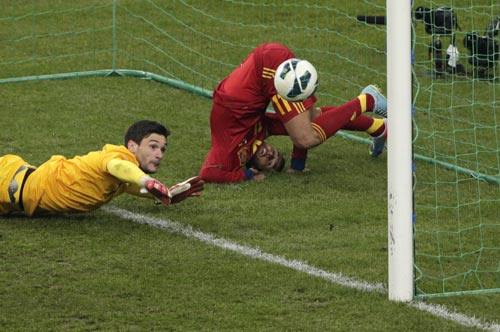 Spain's Pedro Rodriguez Ledesma (R) scores against France's Hugo Lloris (L) during their 2014 World Cup qualifying soccer match at the Stade de France stadium