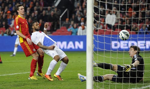 Jeremain Lens (C) of the Netherlands scores a goal past Romania's Florin Gardos and goalkeeper Costel Fane Pantilimon during their 2014 World Cup qualifying soccer match