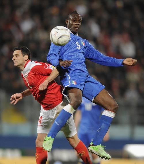 Mario Balotelli of Italy and Gareth Sciberras of Malta compete for the ball during the FIFA 2014 World Cup qualifier match between Malta and Italy