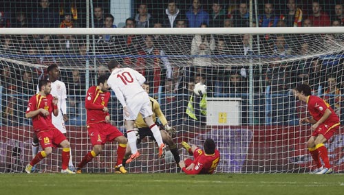 England's Wayne Rooney (C) heads to score against Montenegro during their 2014 World Cup qualifying soccer match at the City Stadium