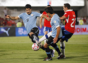 Uruguay's Luis Suarez (left) is challenged by Chile's Marcelo Diaz (right) during their 2014 World Cup qualifying match in Santiago on Tuesday