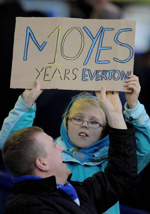 A fan holds a sign acknowledging Everton Manager David Moyes' completion of 10 years
