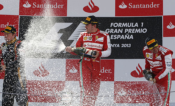 Fernando Alonso of Spain (centre) celebrates on the podium with second-place Lotus Formula One driver Kimi Raikkonen of Finland (left) and third-place Ferrari Formula One driver Felipe Massa of Brazil after the Spanish F1 Grand Prix on Sunday