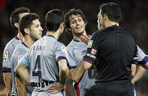 Osasuna's Alejandro Arribas (C) argues with the referee