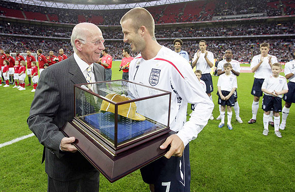 England's David Beckham (right) receives his 100th cap from Sir Bobby Charlton before the team's international friendly against the US at Wembley Stadium in London May 28, 2008