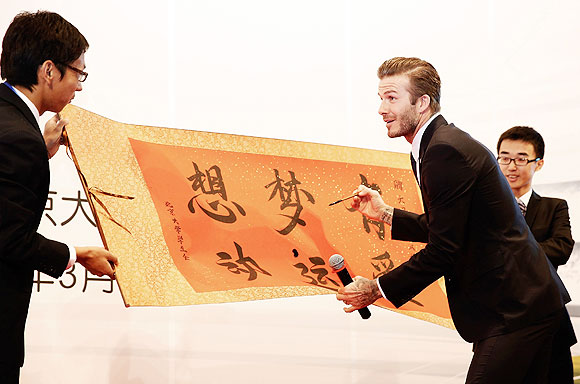 David Beckham learns Chinese calligraphy during a visit to Peking University on March 24, 2013 in Beijing, China. David Beckham visited the country at the invitation of the China Football Association as China's first international ambassador