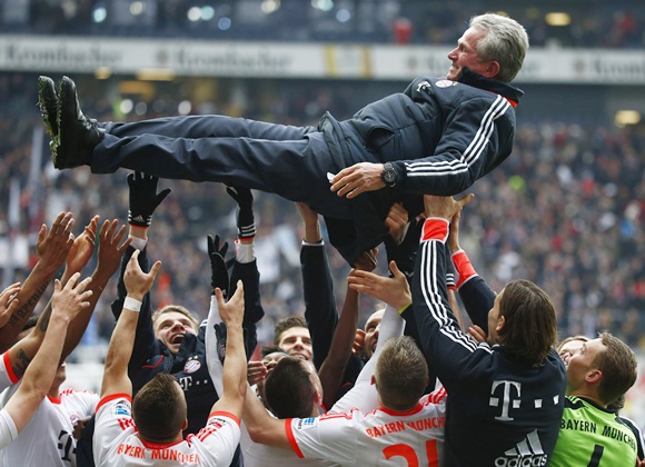 Bayern Munich's players throw coach Jupp Heynckes in the air