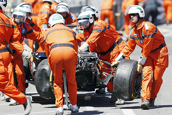 Safety personnel remove the wrecked car of Williams Formula One driver Pastor Maldonado after a crash, during the Monaco Grand Prix on Sunday