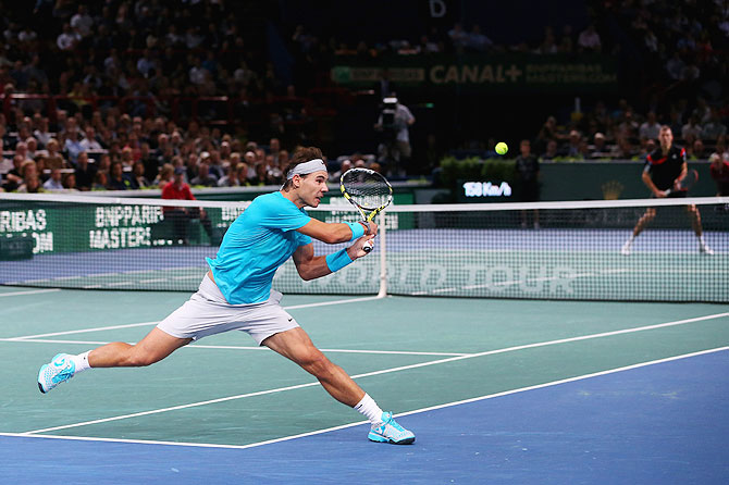 Rafael Nadal of Spain stretches to play a backhand against Jerzy Janowicz of Poland during the BNP Paribas Masters at Palais Omnisports de Bercy in Paris on Thursday