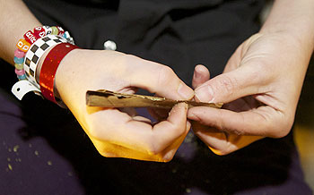 A man rolls up a marijuana joint