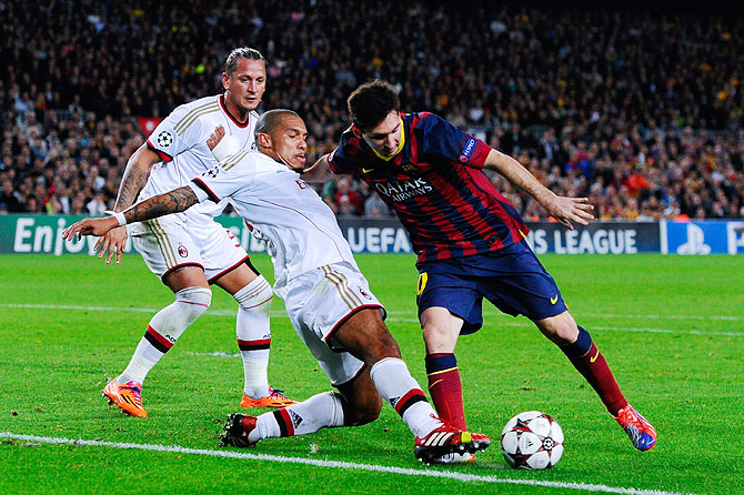 Lionel Messi of FC Barcelona duels for the ball with Nigel de Jong of AC Milan during the UEFA Champions League Group H match at Camp Nou in Barcelona on Wednesday