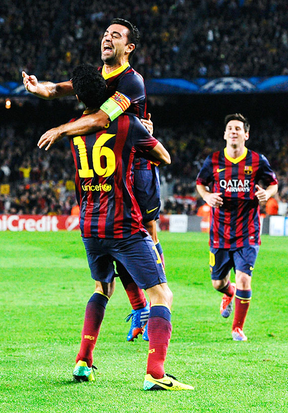 Sergio Busquets (left) of FC Barcelona celebrates with teammate Xavi Hernandez after scoring his team's second goal during their UEFA Champions League Group H match against AC Milan at Camp Nou in Barcelona on Wednesday