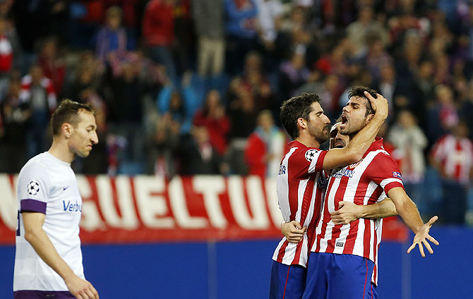 Atletico Madrid's Diego Costa celebrates with teammates Raul Garcia (left) and Juan Francisco Torres Juanfran (center) after scoring against Austria Vienna during their Champions League Group G match at Vicente Calderon stadium in Madrid on Wednesday