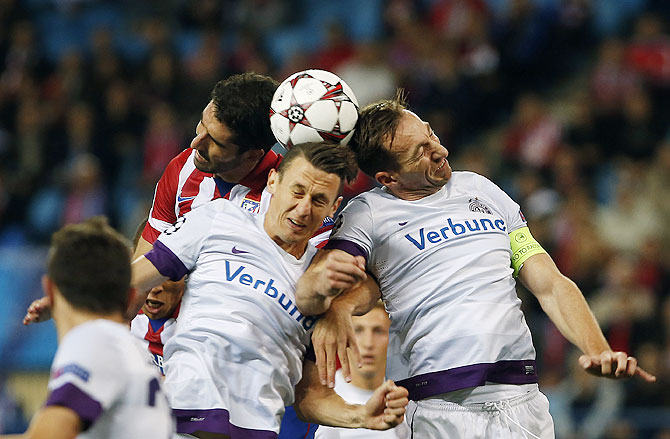 Atletico Madrid's Raul Garcia (left) fights to head the ball with Austria Vienna's Florian Mader (centre) and Manuel Ortlechner during their Champions League Group G match at Vicente Calderon stadium in Madrid on Wednesay