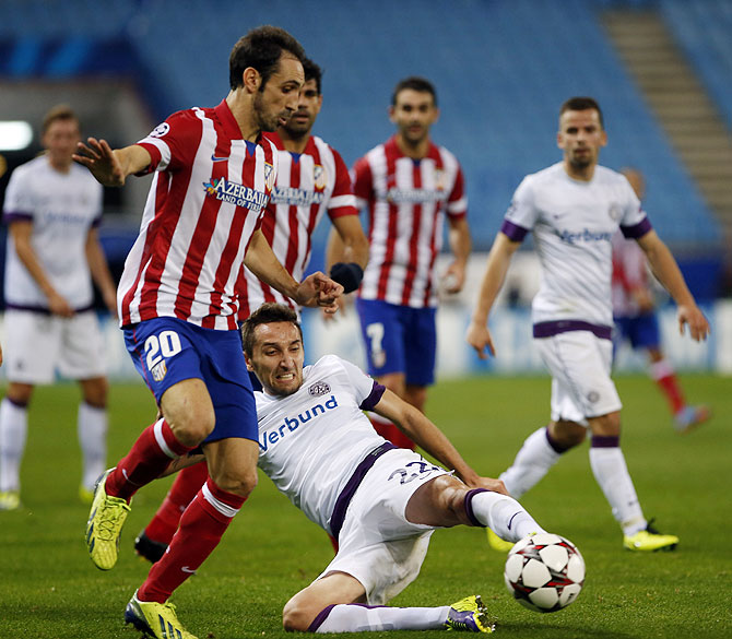 Atletico Madrid's Juan Francisco Torres Juanfran (left) and Austria Vienna's Marin Leovac vie for possession during their Champions League Group G match at Vicente Calderon stadium in Madrid on Wednesday