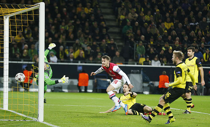 Arsenal's Aaron Ramsey (centre) scores a goal past Borussia Dortmund's goalkeeper Roman Weidenfeller during their Champions League Group F match in Dortmund on Wednesday