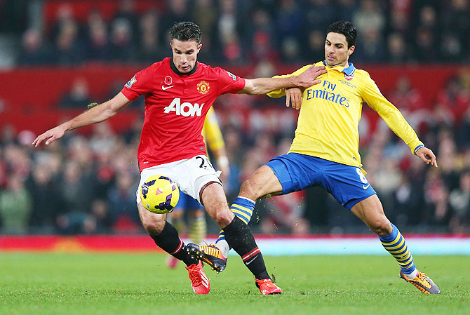 Robin van Persie of Manchester United and Mikel Arteta of Arsenal fight for possession during their Premier League match at Old Trafford in Manchester on Sunday