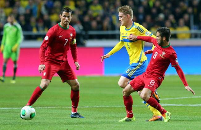 Rasmus Elm (centre) of Sweden battles for the ball with Ronaldo (No 7) and Joao Moutinho (No 8)