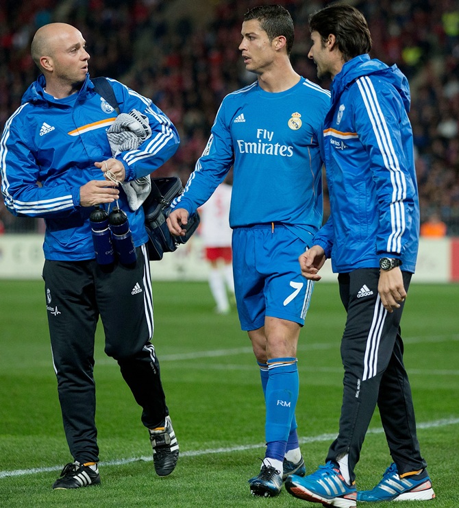 Cristiano Ronaldo of Real Madrid CF leaves the pitch after a pain surrounded by Real Madrid medical staff