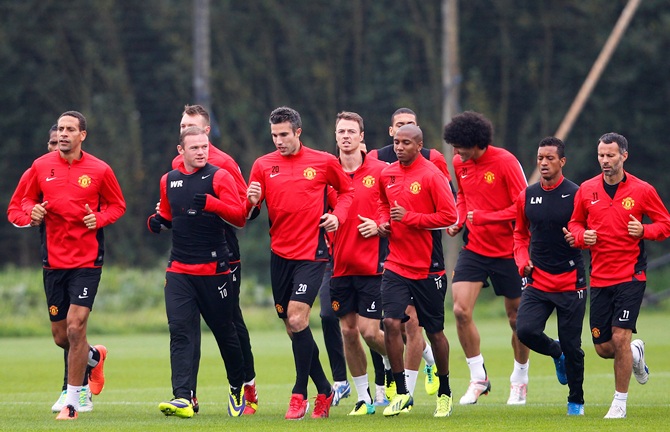 Manchester United players warm up during a training session