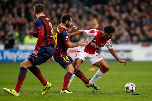 Danny Hoesen of Ajax battles for the ball with Javier Mascherano and Gerard Pique of Barcelona