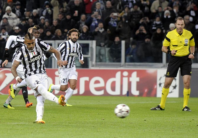 Arturo Vidal of Juventus shoots to score a penalty against FC Copenhagen