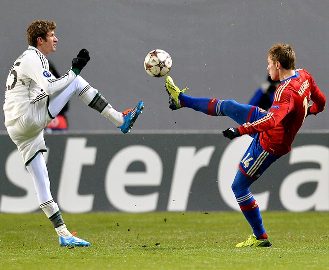 Thomas Muller of Bayern Munich tries to get the ball past Kirill Nababkin (right) of CSKA Moscow