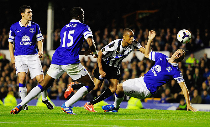 Newcastle player Loic Remy beats Phil Jagielka to score the second newcastle goal against Everton during their Premier League match at Goodison Park on Monday