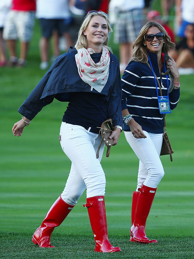 Tiger Woods's girlfriend skiier Lindsey Vonn (left) and Fred Couple's girlfriend Nadine Moze walk up a fairway during the Day One Four-Ball Matches of the President's Cup at the Muirfield Village Golf Club in Dublin, Ohio, on Thursday