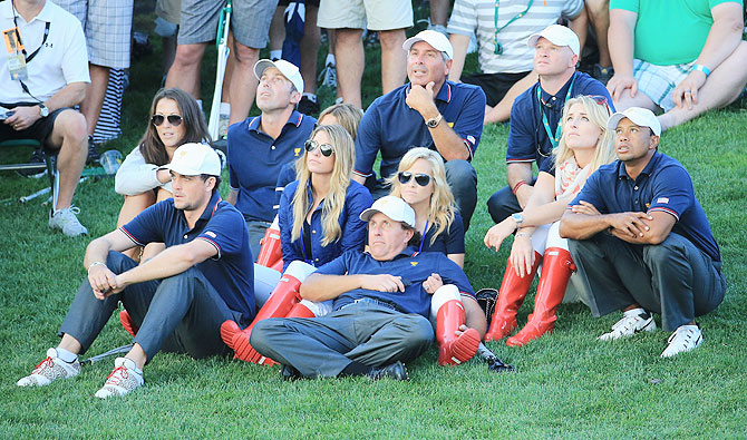 Tiger Woods of the U.S. Team watches the play with his temmates and their partners during the Day One Four-Ball Matches of the Prsident's Cup at the Muirfield Village Golf Club in Dublin, Ohio, on Thursday