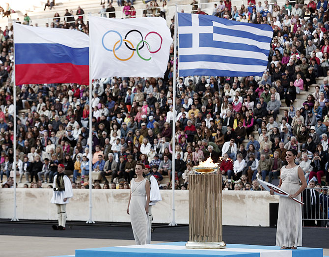 Greek actress Ino Menegaki (right), playing the role of high priestess, stands next to an altar during a handover ceremony of the Olympic flame for the Sochi 2014 Winter Games at the Panathenean stadium in Athens on Saturday