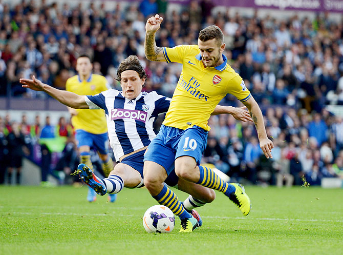 Jack Wilshere of Arsenal is challenged by Billy Jones of   West Bromwich Albion during their English Premier League match at The Hawthorns in West Bromwich on Sunday