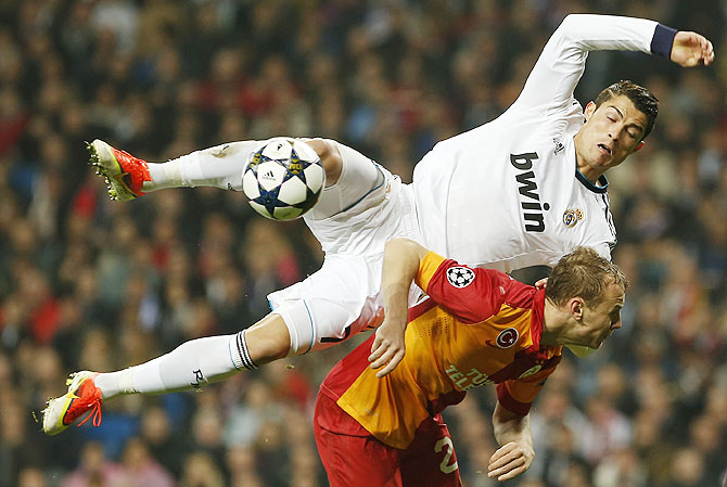 Real Madrid's Cristiano Ronaldo is challenged by Galatasaray's Semih Kaya during a Champions League match