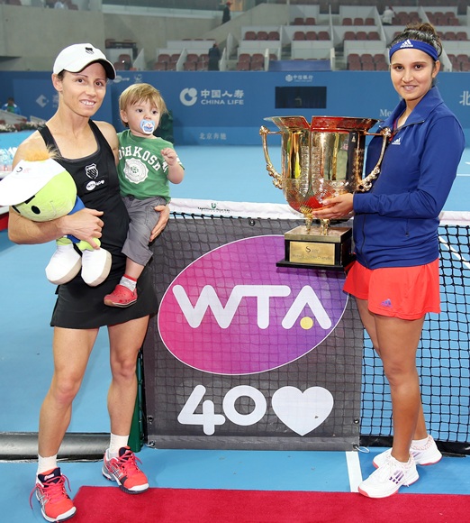 Cara Black of Zimbabwe, holding her son Lachlan, and Sania Mirza