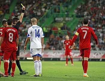 Portugal's Cristiano Ronaldo (R) receives a yellow card from the referee during the match against Israel