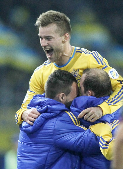 Ukraine's Andriy Yarmolenko (top) celebrates with his team mates