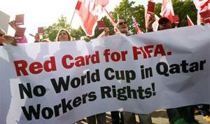 Members of the Swiss UNIA workers union display red cards and shout slogans during a protest in front of the headquarters of soccer's international governing body FIFA