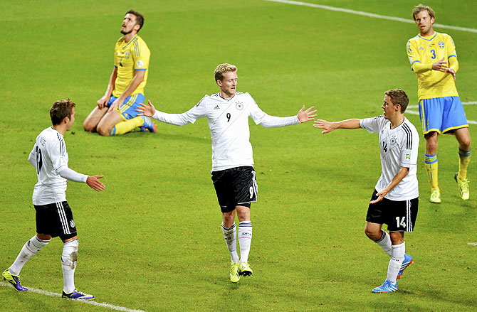 Germany's Andre Schuerrle (centre) celebrates his goal against Sweden with teammates Mario Goetze (L) and Max Kruse while Sweden's Per Nilsson (2nd from left) and Mikael Antonsson react during their 2014 World Cup qualifying match at Friends Arena in Stockholm on Tuesday
