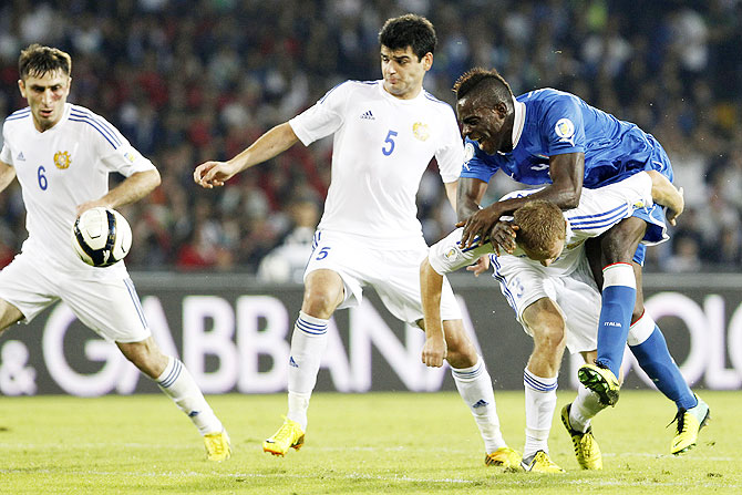 Armenia's Karlen Mkrtchyan (left), Robert Arzumanyan (2nd from left) and Varazdat Haroyan (right) challenge Italy's Mario Balotelli during their 2014 World Cup qualifying match at San Paolo stadium in Naples on TUesday