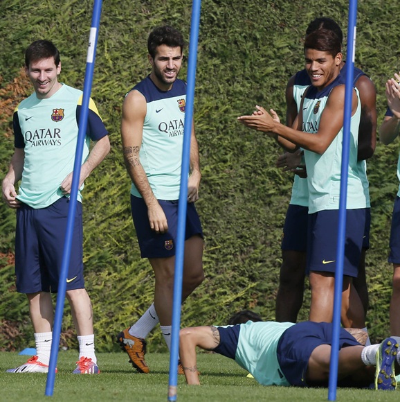 FC Barcelona's Lionel Messi and Cesc Fabregas (right) joke with teammates