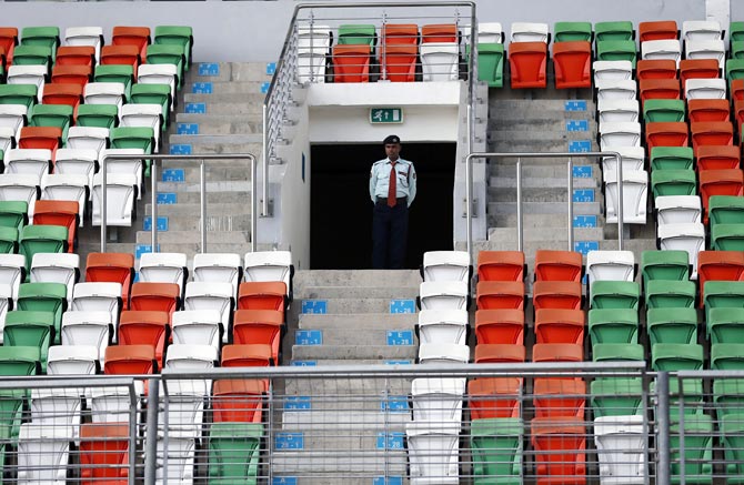 A security guard stands amid empty seats on the grandstand at the Buddh International Circuit in Noida