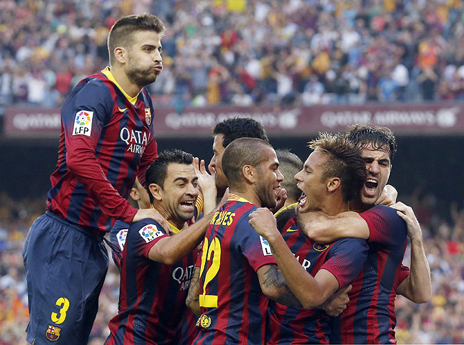 Barcelona's Neymar (2nd from right) is congratulated by teammates (left to right) Gerard Pique, Xavi, Dani Alves and Cesc Fabregas after scoring a goal against Real Madrid during their La Liga Clasico match at Nou Camp stadium in Barcelona on Saturday