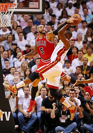Carlos Boozer #5 of the Chicago Bulls blocks Chris Bosh #1 of the Miami Heat during a game at American Airlines Arena on Tuesday