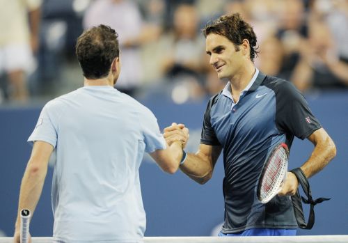Roger Federer of Switzerland is congratulated by Adrian Mannarino of France