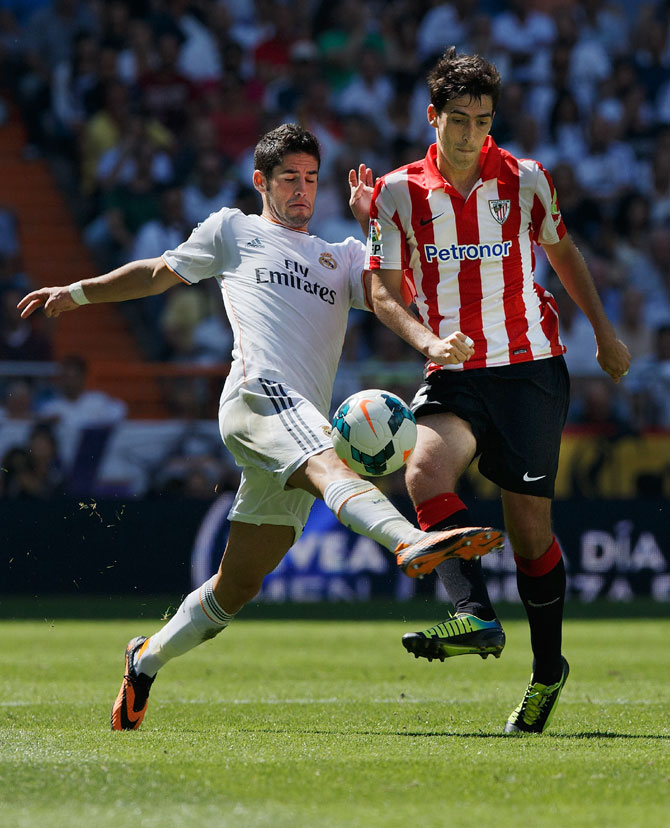 Real Madrid's Isco (left) and Athletic Bilbao's Andoni Iraola (right) vie for possession during their La Liga match at Estadio Santiago Bernabeu in Madrid on Saturday