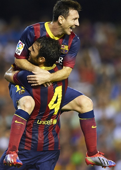 Lionel Messi of Barcelona celebrates after scoring his third goal with his teammate Cesc Fabregas