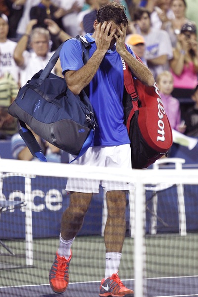 Roger Federer of Switzerland walks off the court after losing to Tommy Robredo