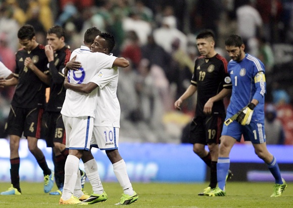 Luis Fernando Garrido (19) and Marvin Chavez (10) of Honduras celebrate their team's victory as players of Mexico react