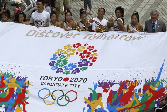 Participants hold a banner during an event celebrating Tokyo being chosen to host the 2020 Olympic Games
