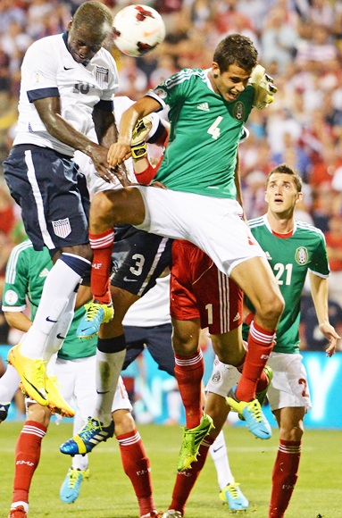 Eddie Johnson of the United States heads the ball past Diego Reyes of the Mexico